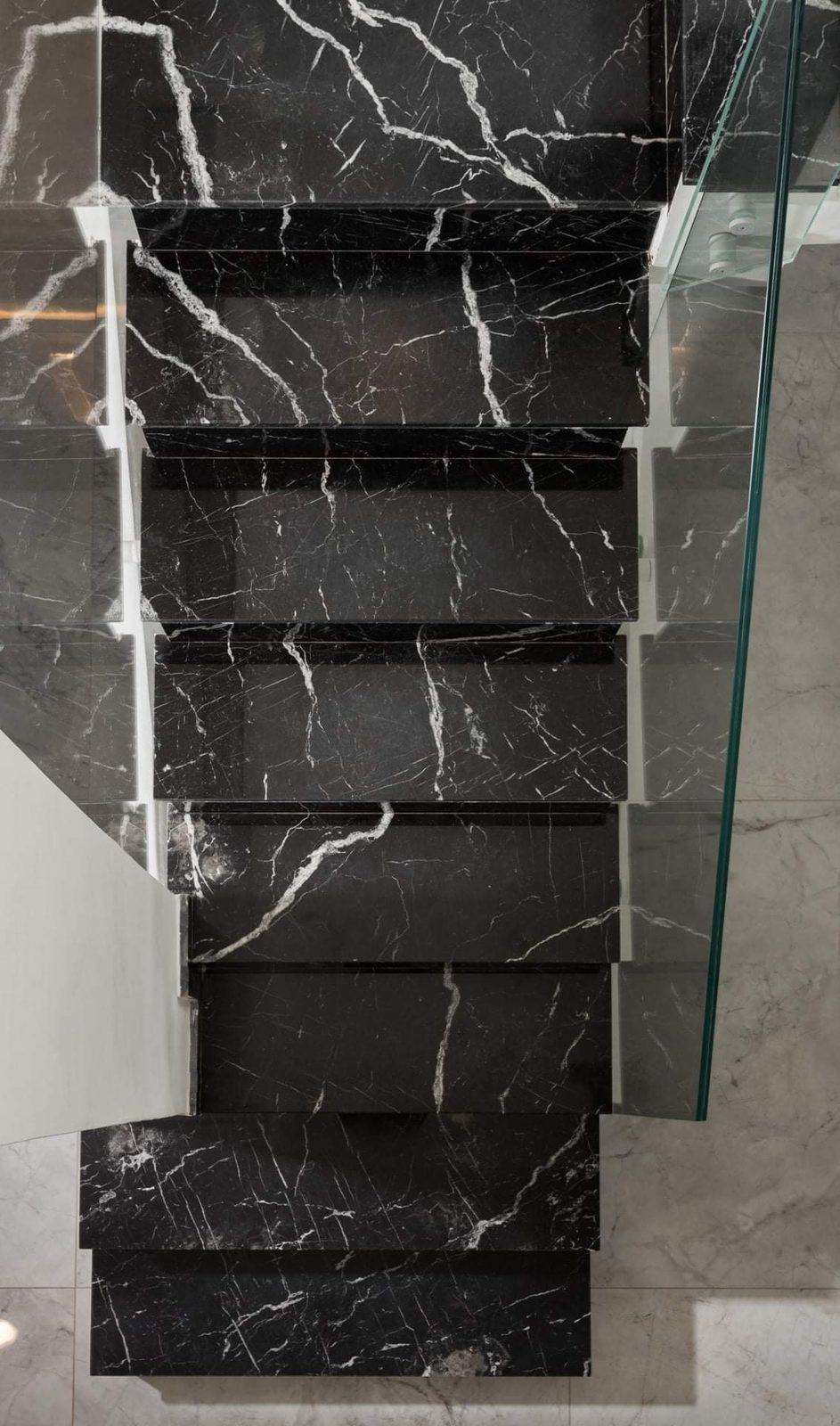 Detail of a marble stair with a glass balustrade