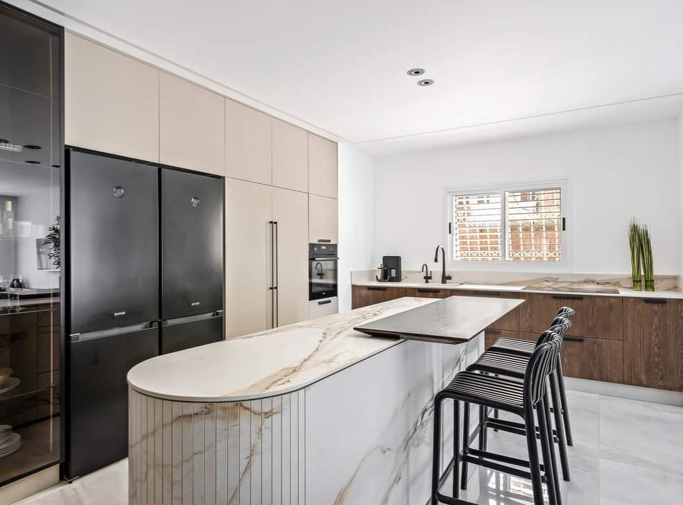 Kitchen with a curved marble island and bar seating