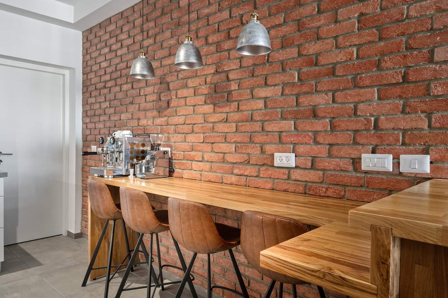 Loft kitchen against exposed brick with a solid timber table