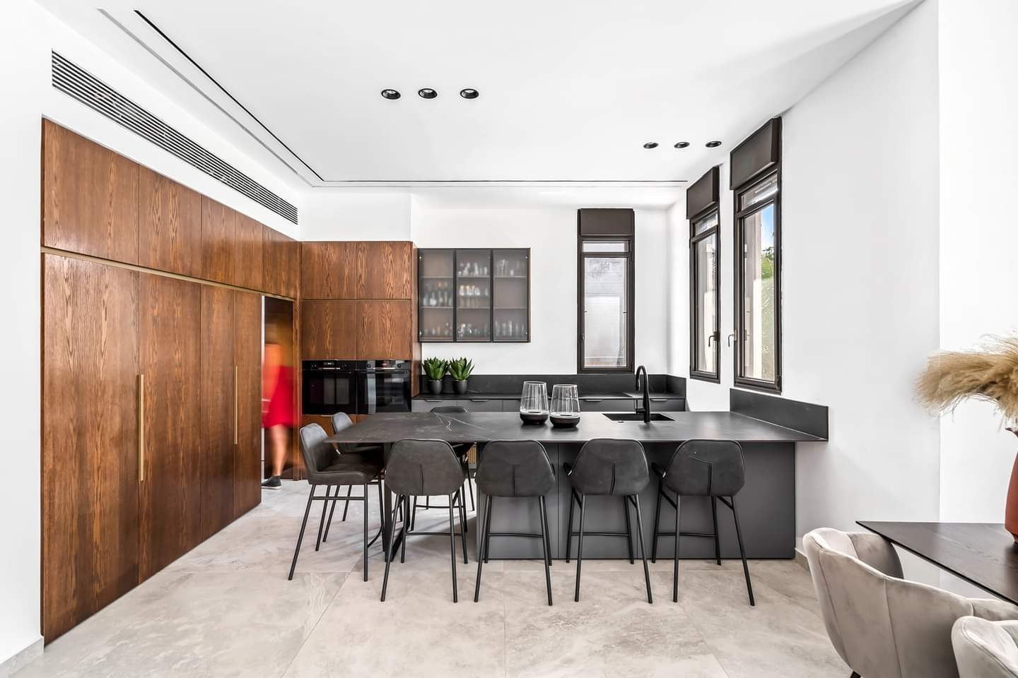 Kitchen integrated into a full-height walnut wall