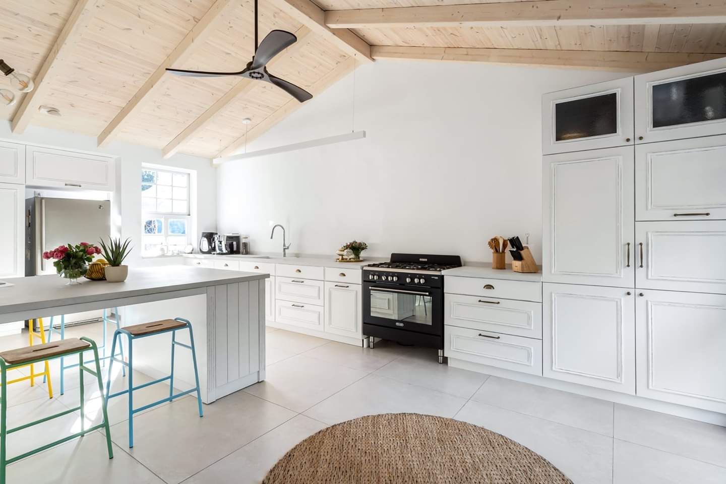 White kitchen beneath a boarded vaulted ceiling