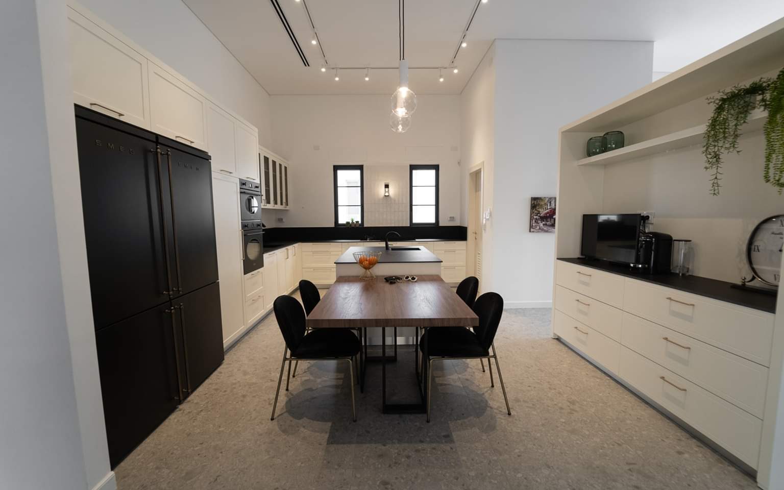 White kitchen opening into the dining room of a villa