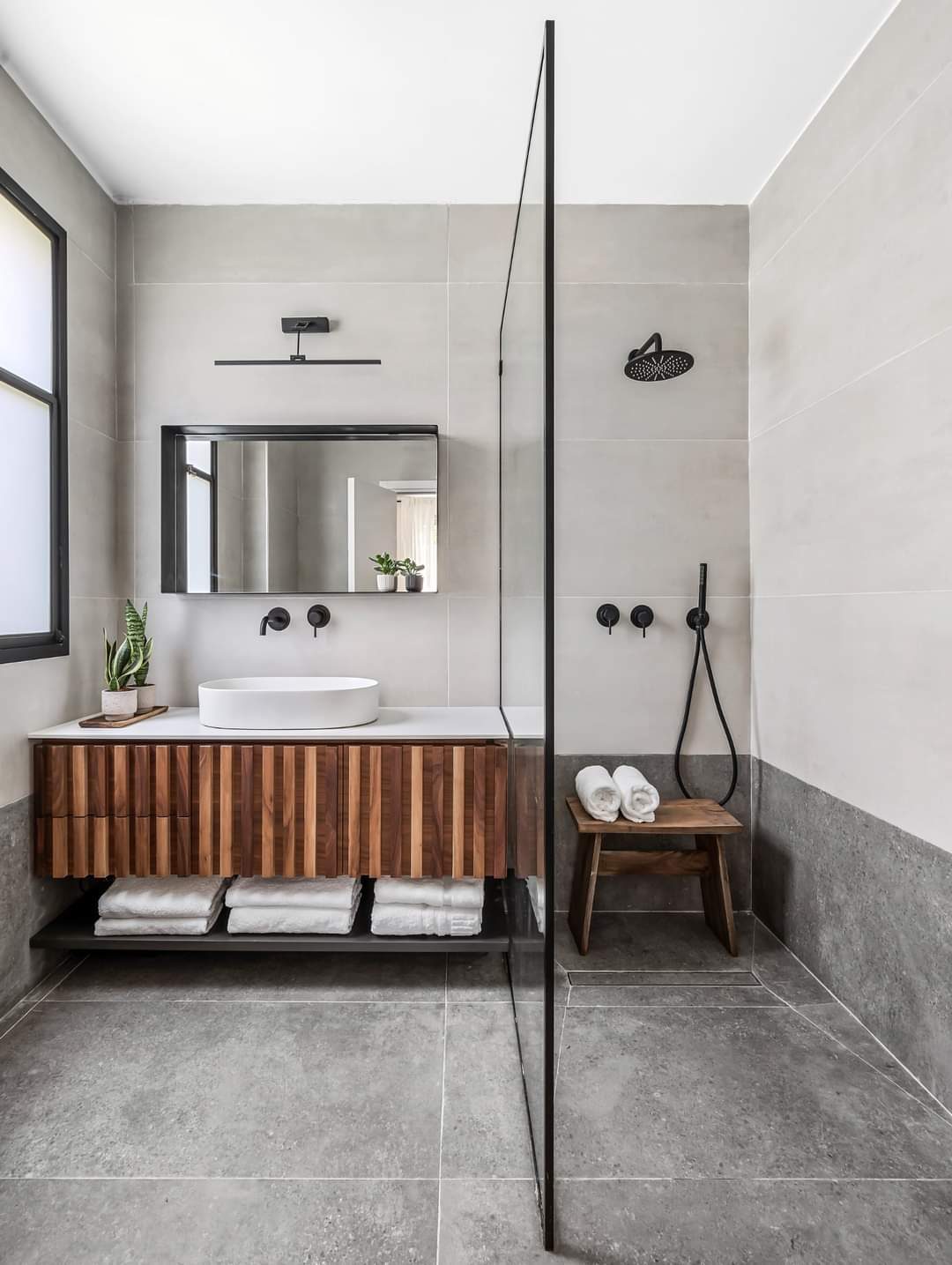 Bathroom with a timber vanity and full-height tiling